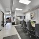 Modern office space inside Monaco & Leetsdale automotive property with conference table, chairs, kitchenette, and natural light.
